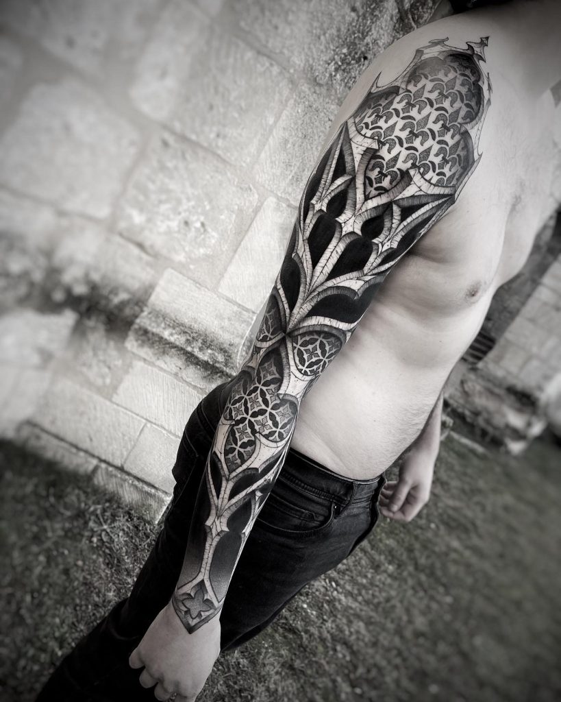 Tatouage architectural inspiré du style gothique avec des gros espaces noirs pour créer du contraste dans ce tatouage de bras complet réalisé par Lahhel à Bordeaux. Prise de rendez-vous