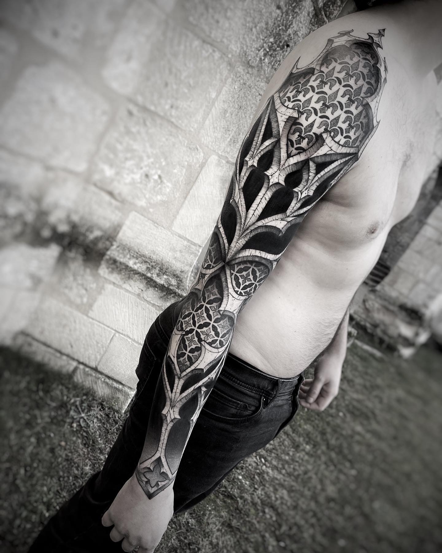 Tatouage architectural inspiré du style gothique avec des gros espaces noirs pour créer du contraste dans ce tatouage de bras complet réalisé par Lahhel à Bordeaux. Prise de rendez-vous