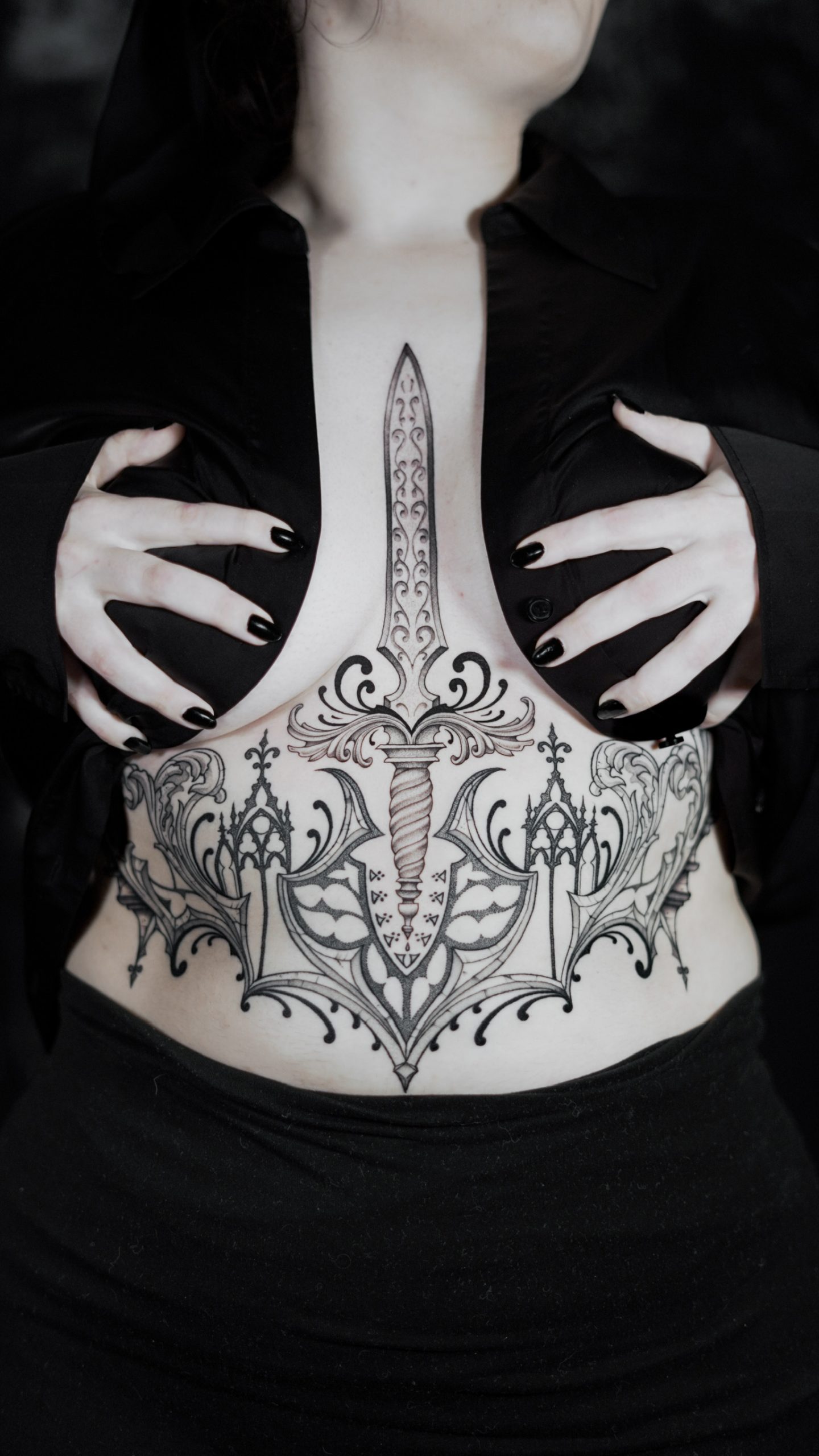 Tatouage ornemental inspiré d’une cathédrale gothique avec une dague stylisée réalisé par Lahhel à Bordeaux.