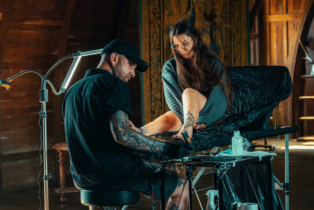 Le tatoueur Lahhel réalise un tatouage gothique sur sa cliente pour un épisode de sa chaîne Youtube De Pierre et d'Encre